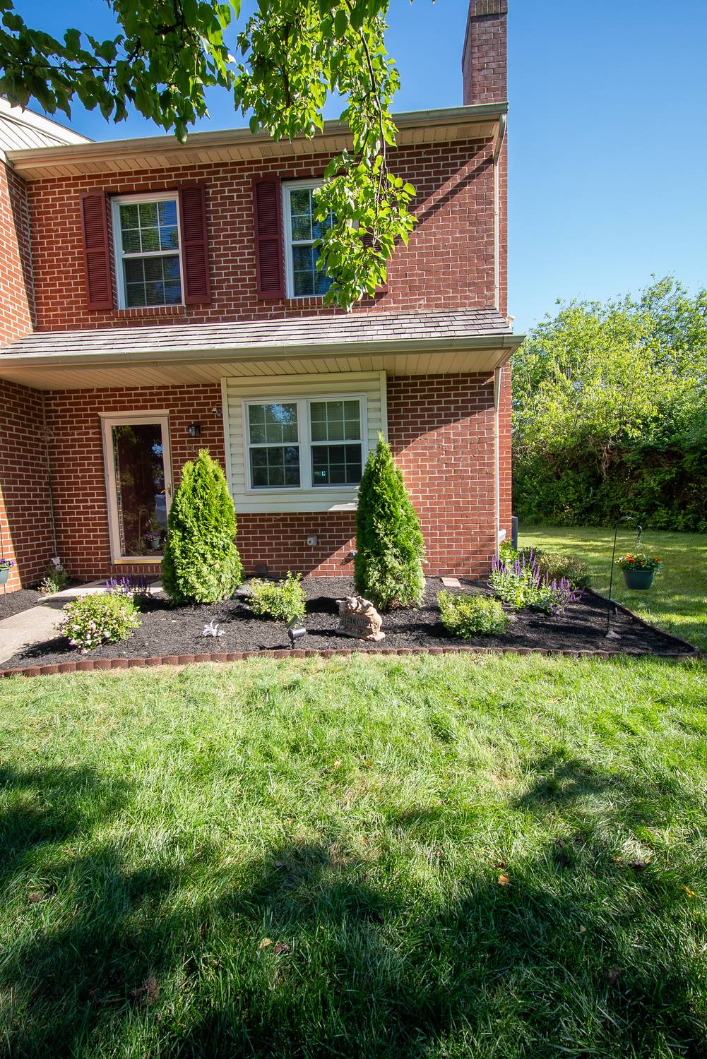 Front of a brick home with refreshed beds